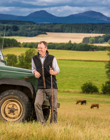 Farmer in field next to Land Rover