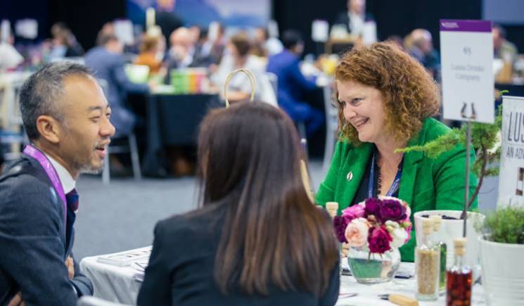 three people sitting at event table